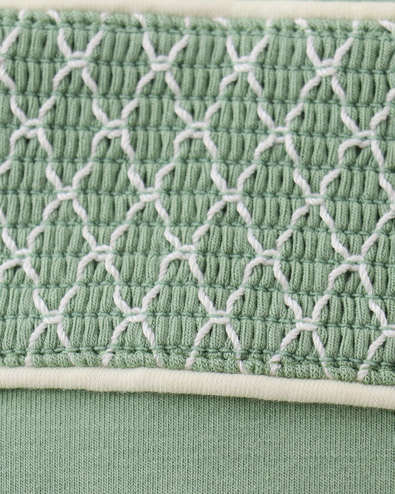 Smocked yoke panel on sage green jon jon with white embroidered net pattern