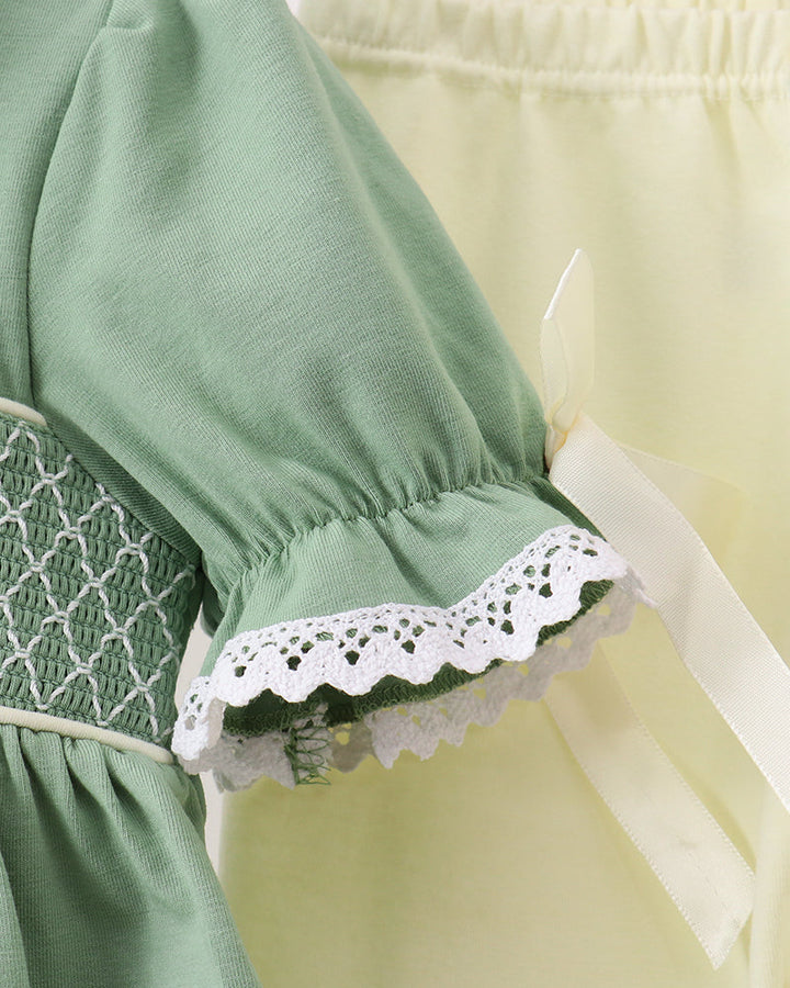 Sage green puff-sleeve top with white lace trim and smocked waist