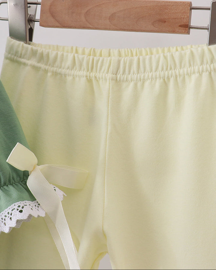 Pale yellow elastic-waist pants with gathered waistband and white bow ties