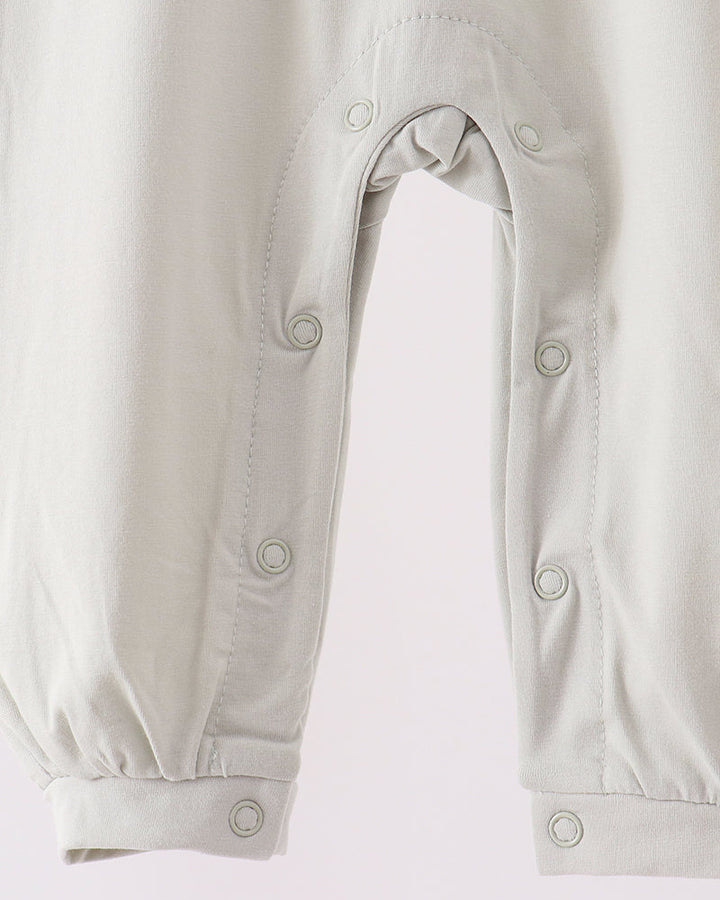 Off-white romper with snap-closure legs and reinforced buttoned openings