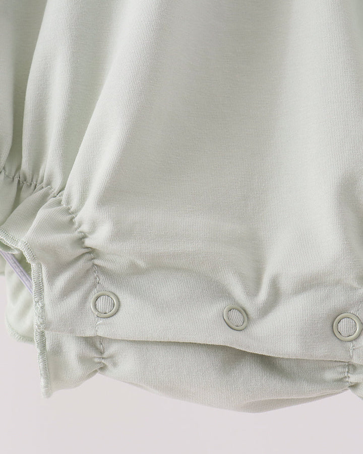 Sage green romper with snap button closure at lower back