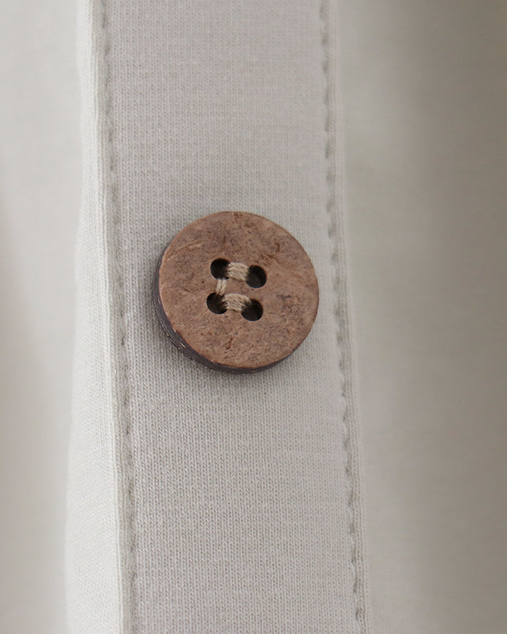 Sage dress front with round wooden-look button closure