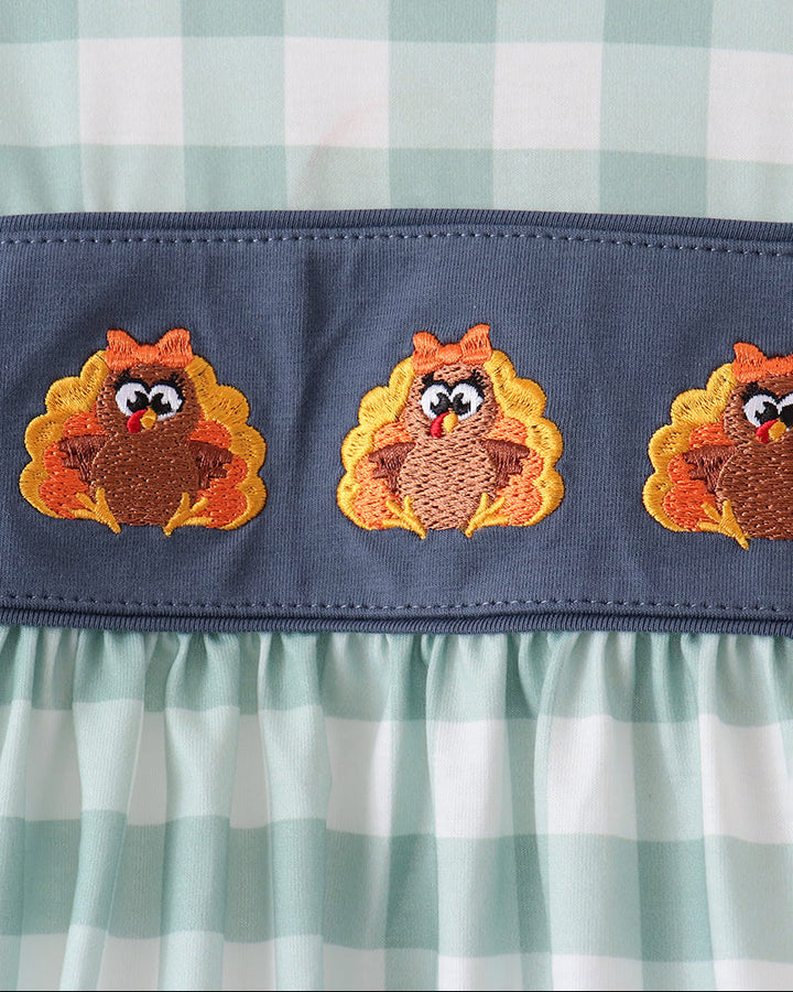 Navy yoke dress with three orange and brown animal embroidery panels and sage gingham skirt