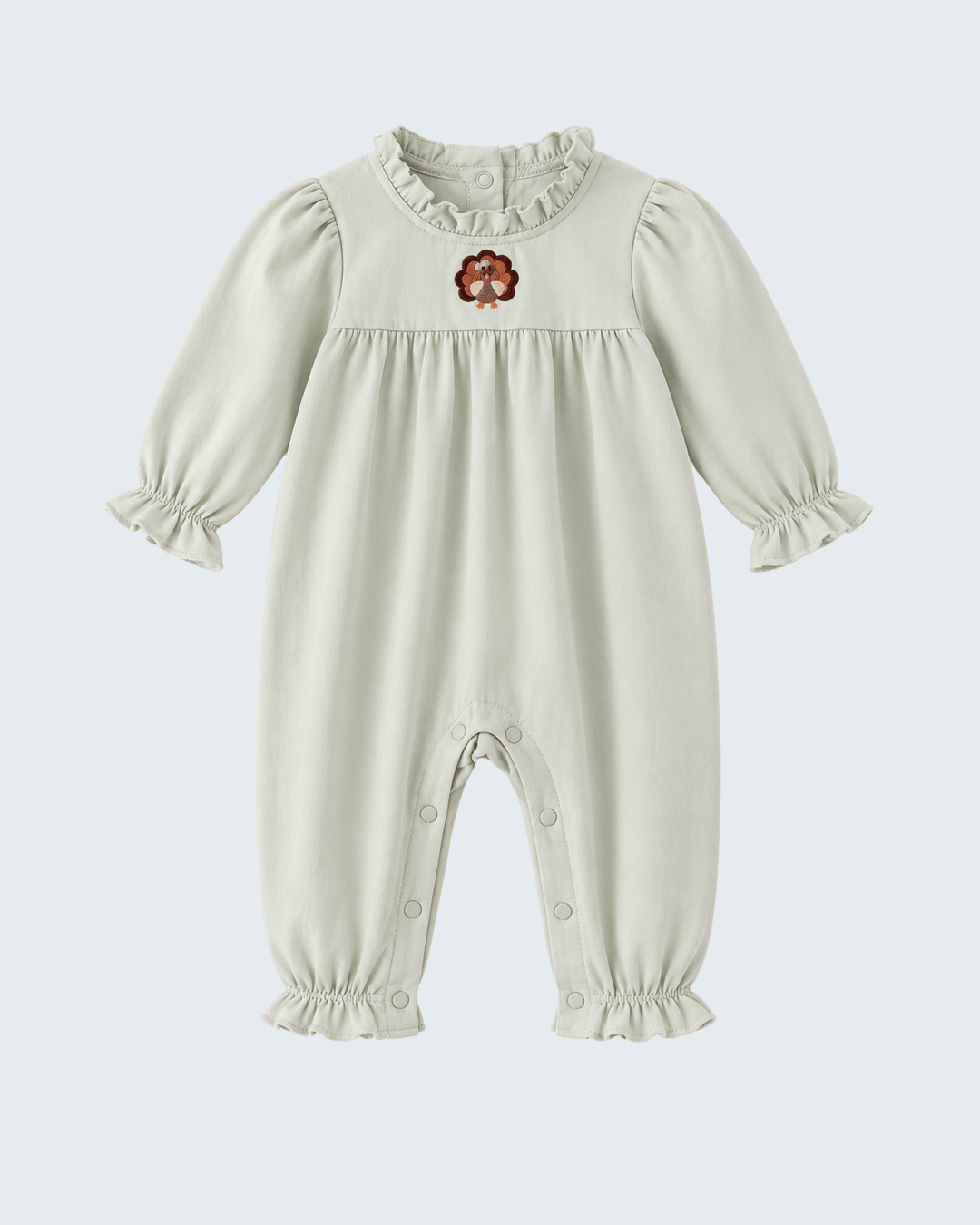 Sage baby romper with ruffled neck and embroidered turkey motif on chest, long sleeves.