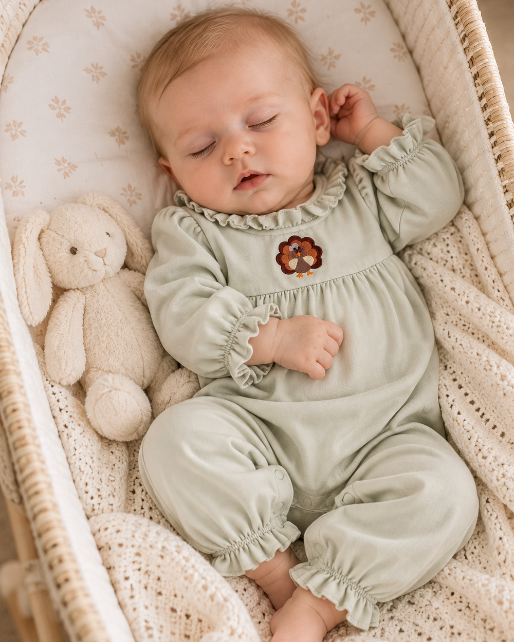 Sage baby romper with ruffled collar, embroidered turkey motif, cuffed long sleeves.