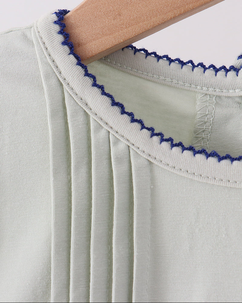 Sage ruffle top collar trim with blue scalloped edging, close-up