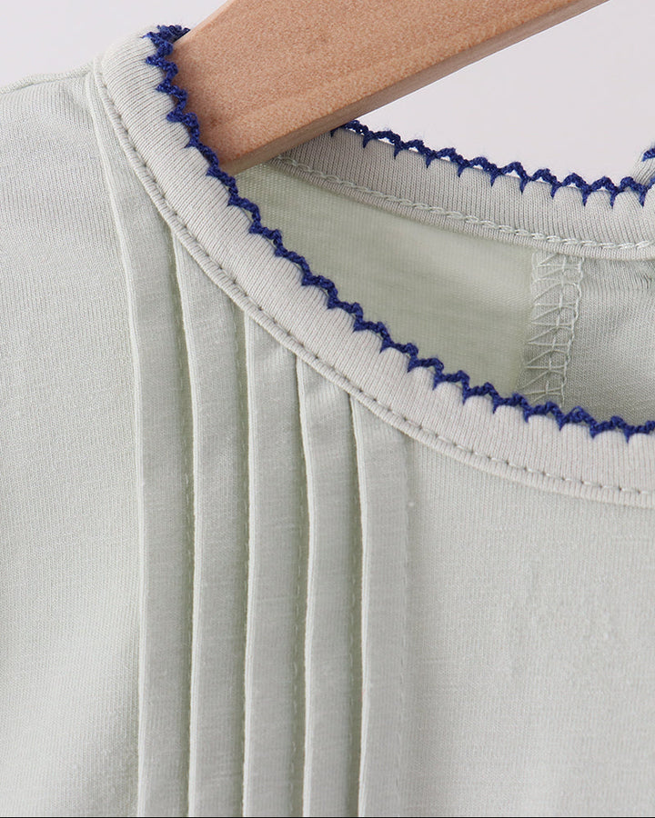 Sage ruffle top collar trim with blue scalloped edging, close-up