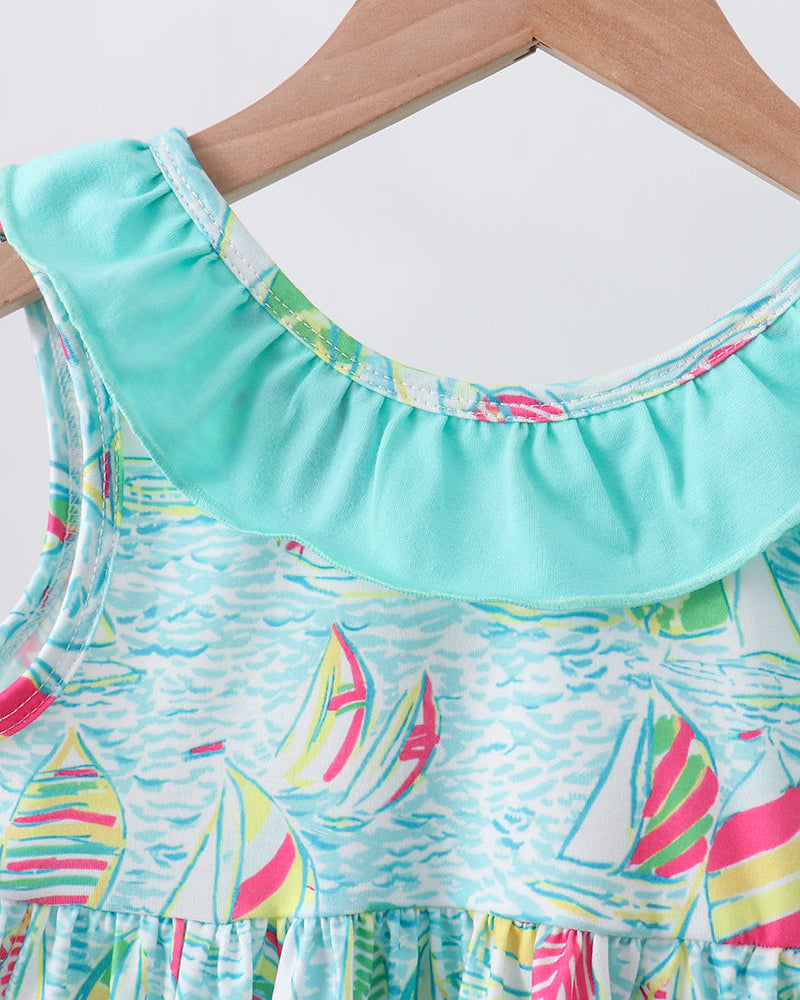 Colorful dress with sailboat pattern on a hanger against a white background