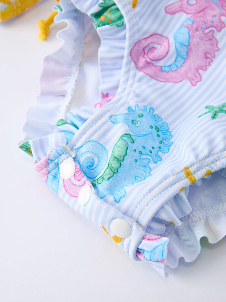 Colorful baby swimsuit with cartoon sea horse design on a white background