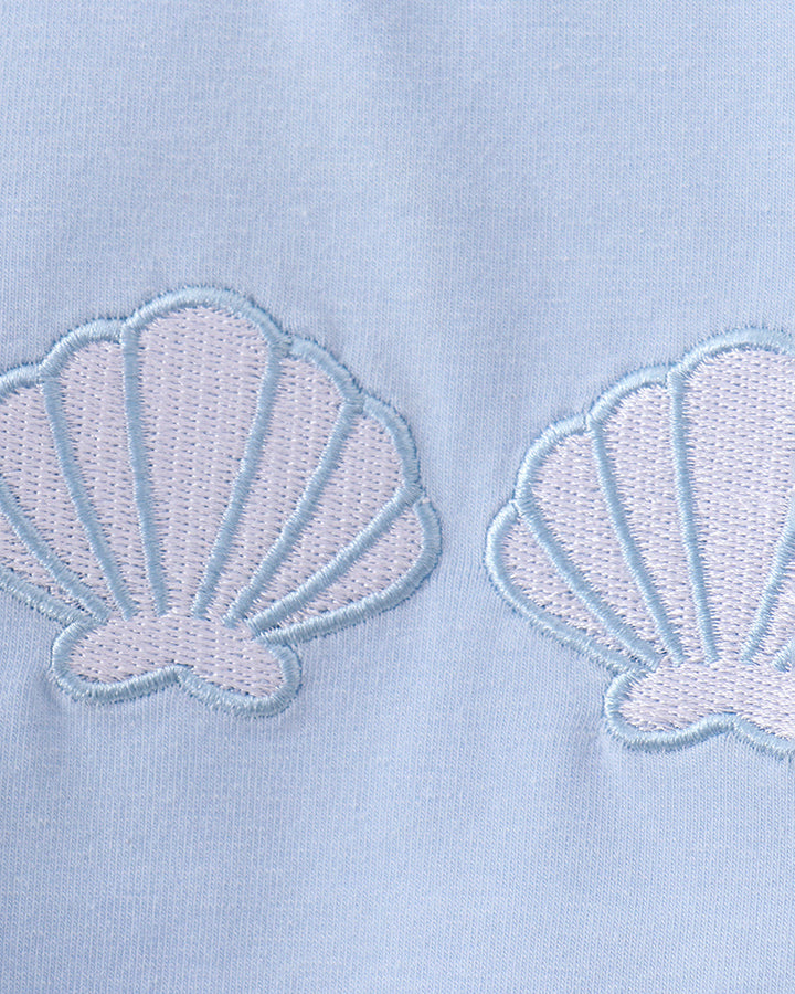 Embroidered seashell stripe set in light blue fabric with shell motifs