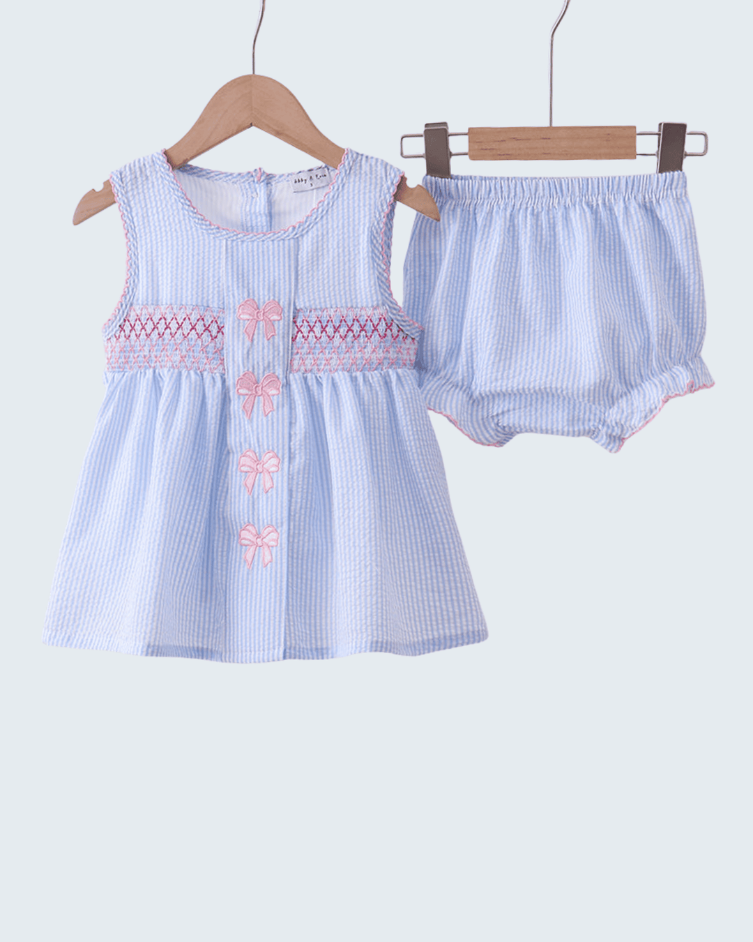 Baby outfit with blue striped top and shorts on a white background