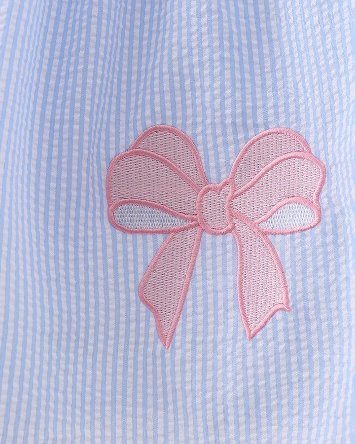Light blue fabric with a pink embroidered bow