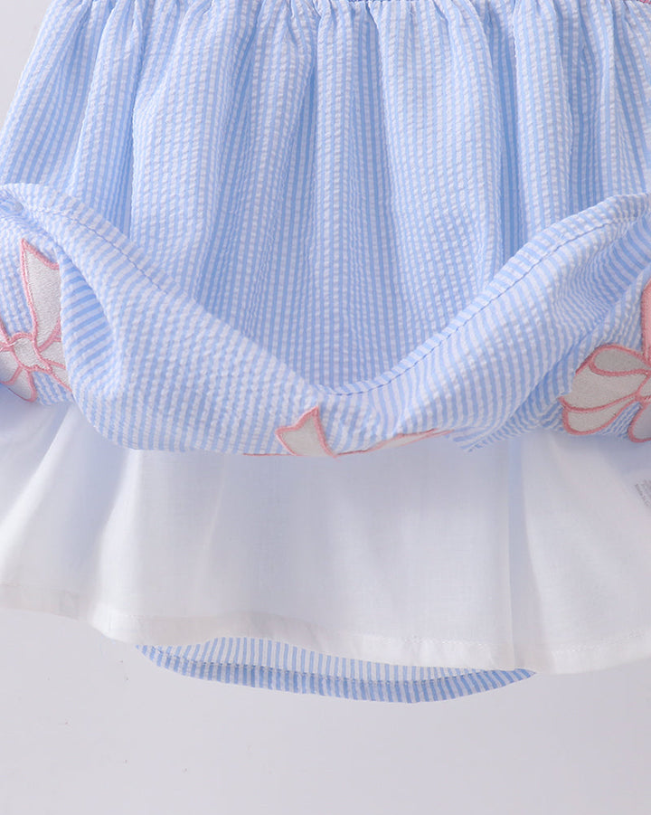 Light blue checkered dress with pink floral patterns on a white background