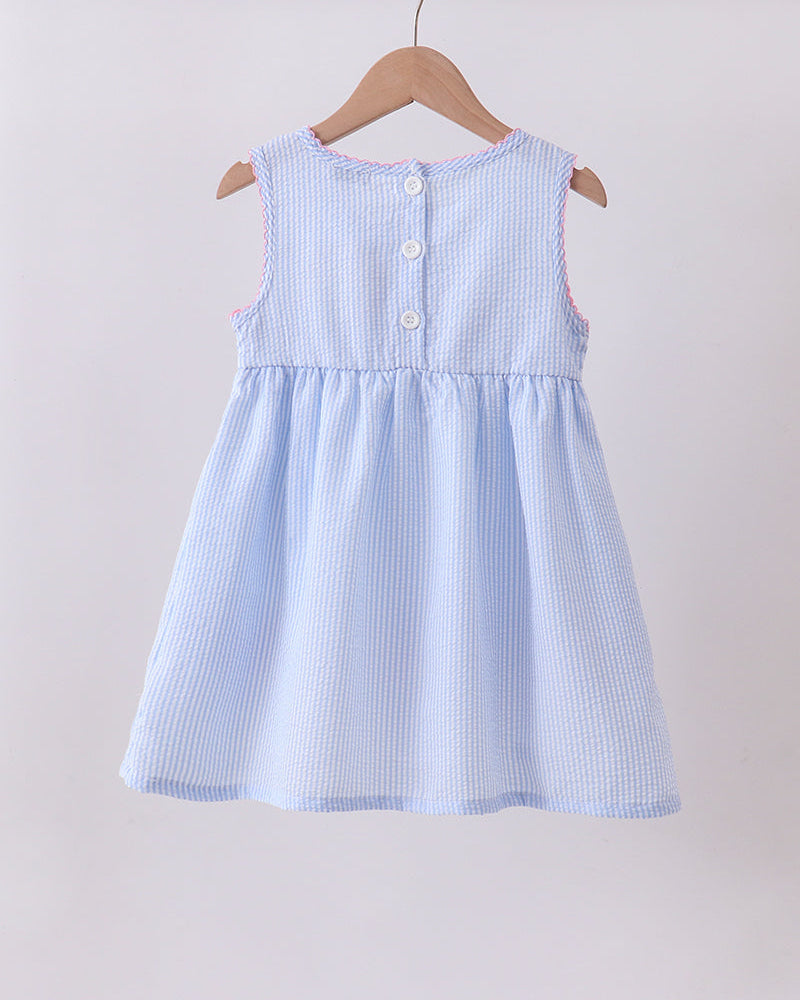 Light blue checkered dress on a wooden hanger against a light background