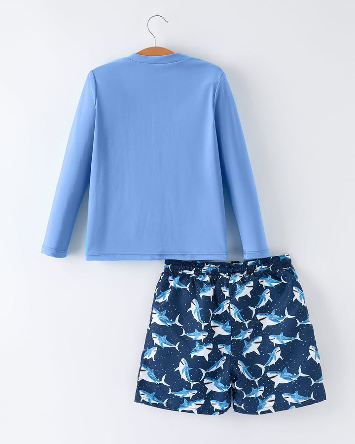 Blue long-sleeve shirt and navy shorts with shark pattern on a white background