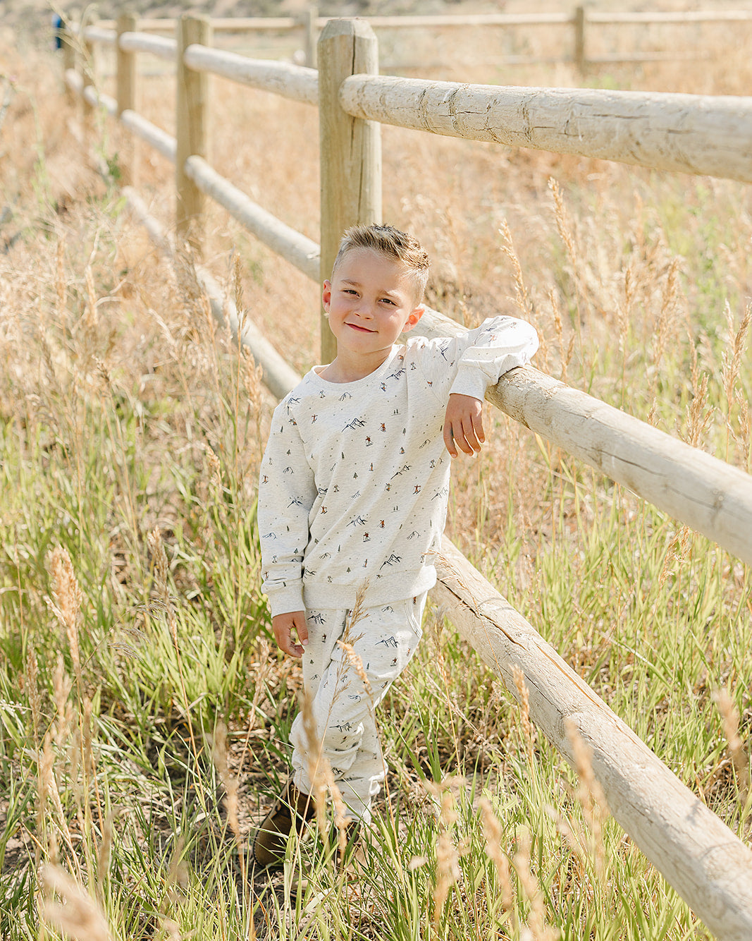 Light gray ski-print sweatshirt and joggers set on child, relaxed standing pose.