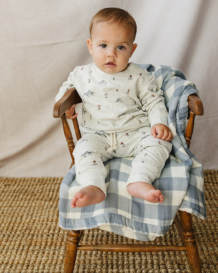 Light gray ski-print sweatshirt and pants set on child, seated posture.