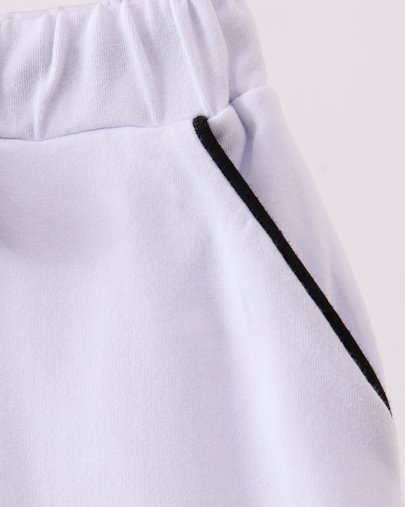 White skort waistband detail with black ribbon tie and long tassel ends