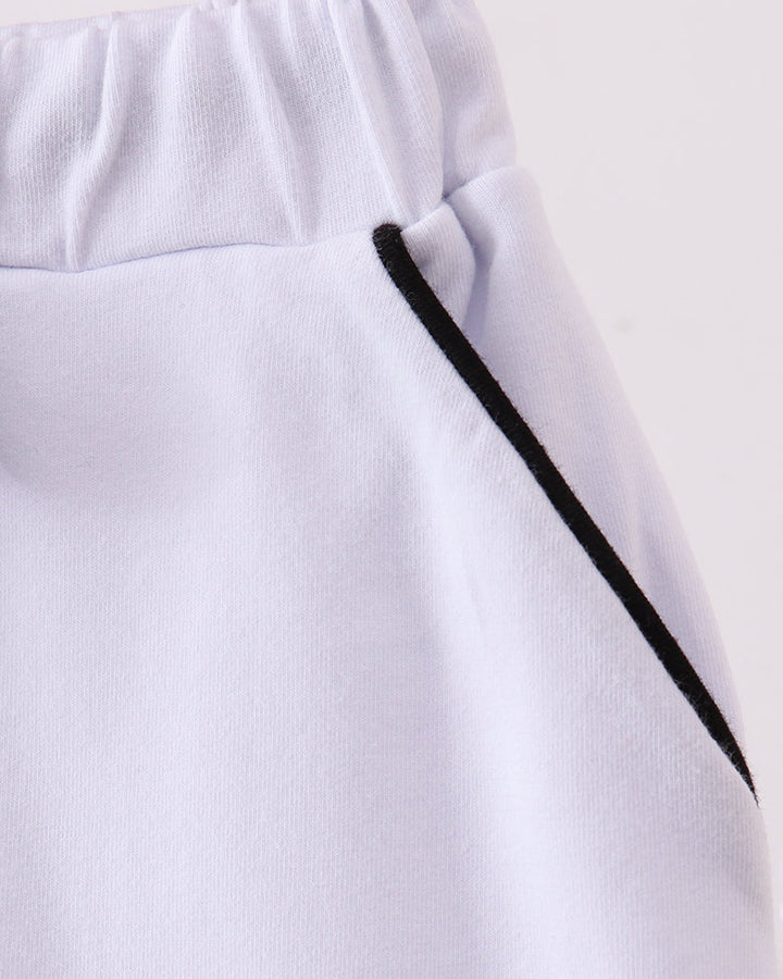 White skort waistband detail with black ribbon tie and long tassel ends