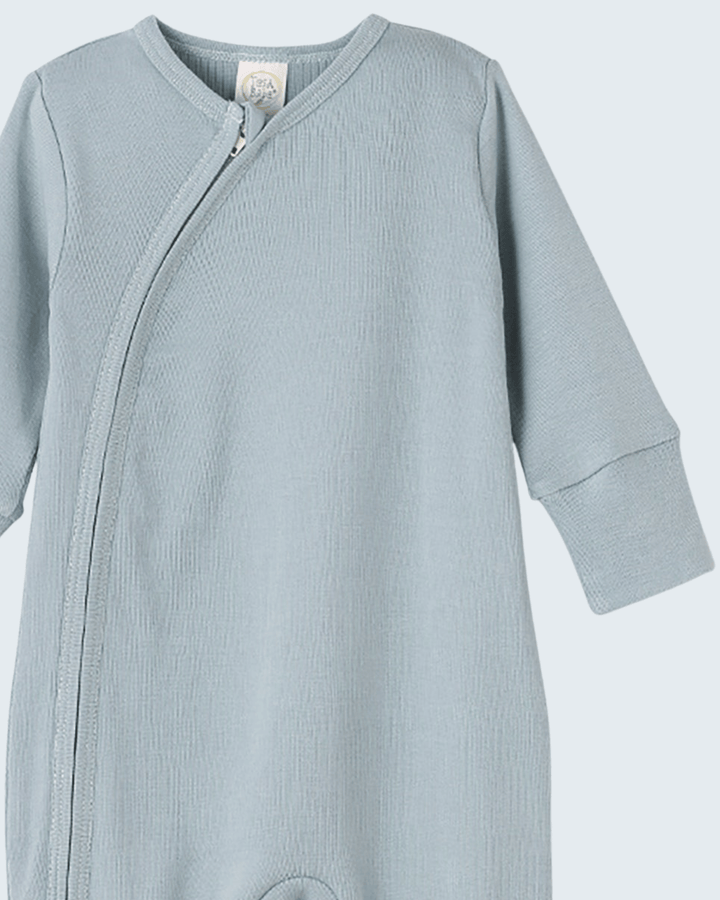 Light blue cotton romper with front diagonal zipper and long sleeves