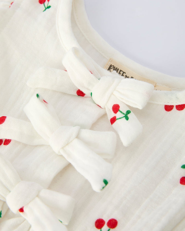 White garment with red cherry designs on a white background