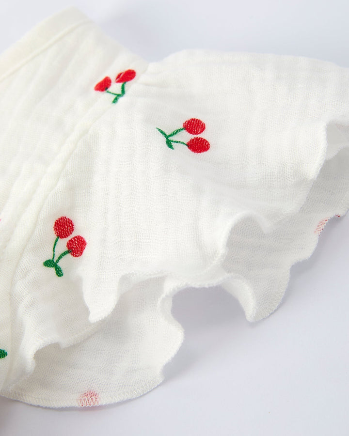 White fabric with red and green embroidered flowers on a white background
