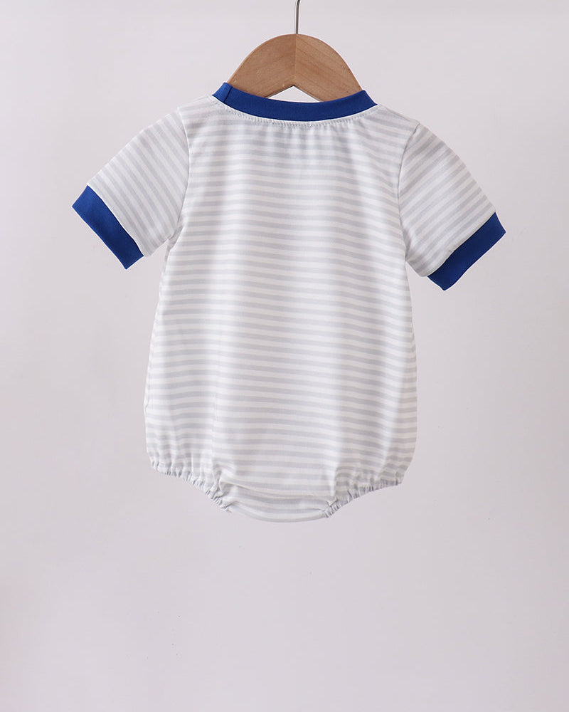 Striped baby romper with blue trim hanging on a wooden hanger against a light gray background