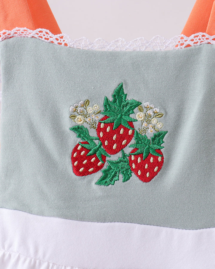 Embroidered strawberries on a light blue fabric with orange and white accents.
