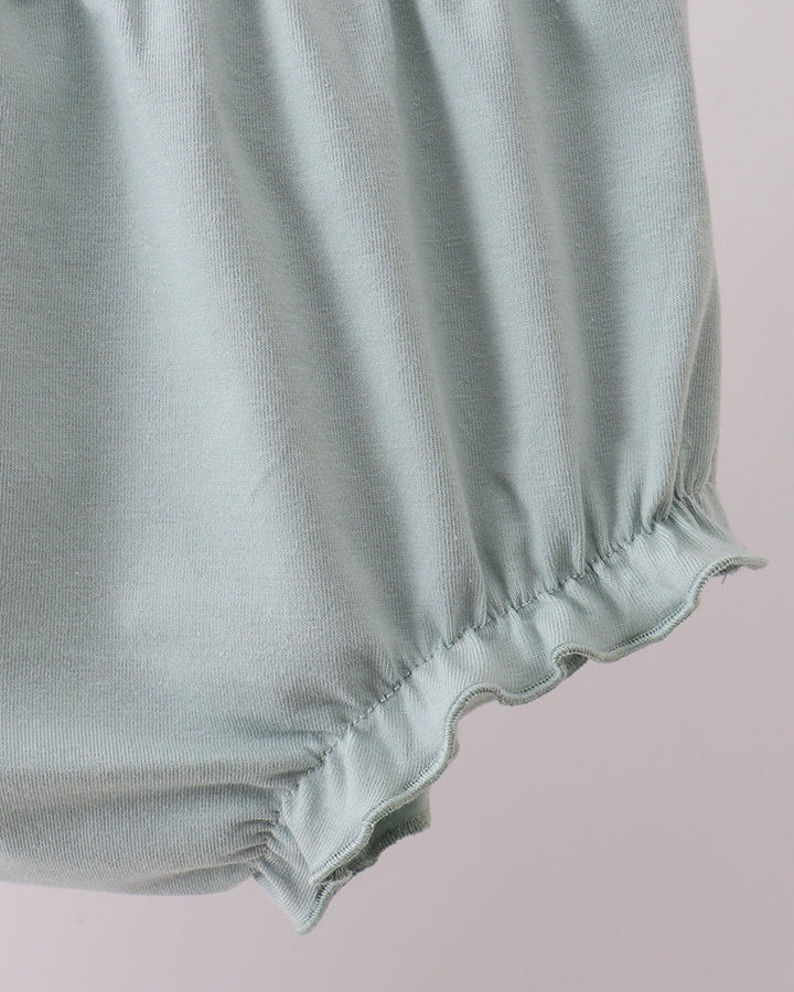 Light blue baby bloomers on a light pink background