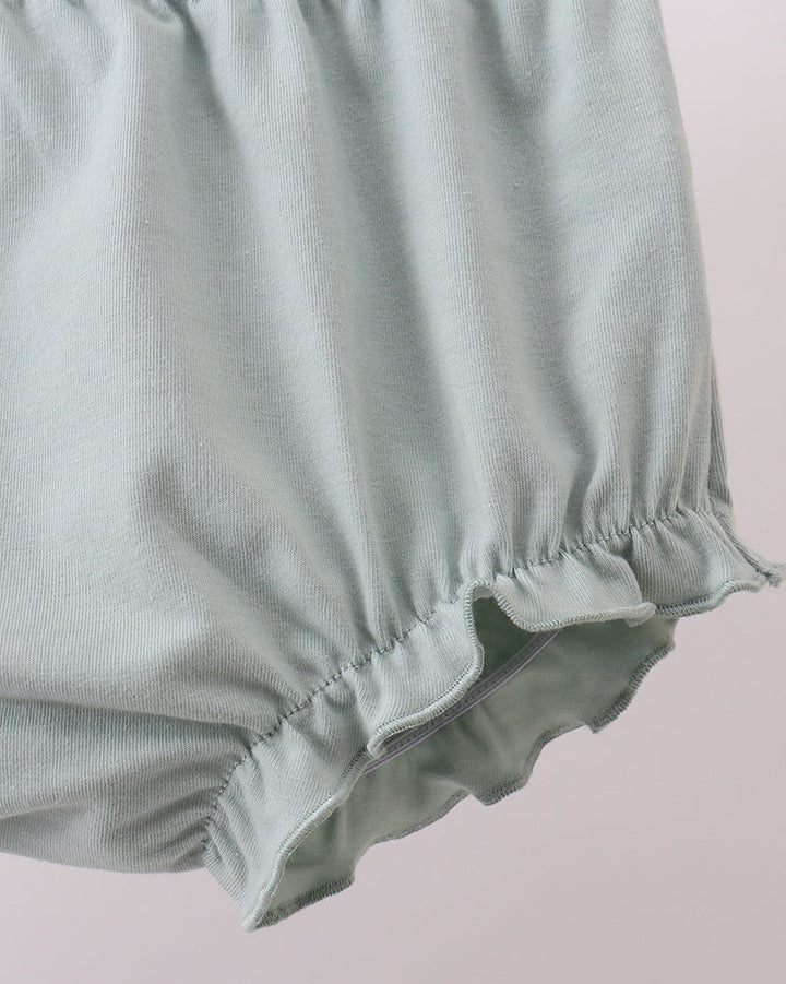 Light green baby bloomers on a plain background