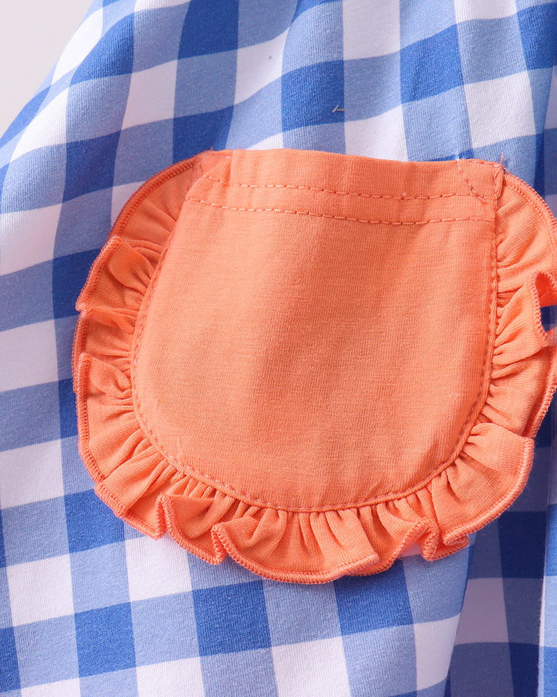 Close-up of an orange pocket on a blue and white checkered fabric
