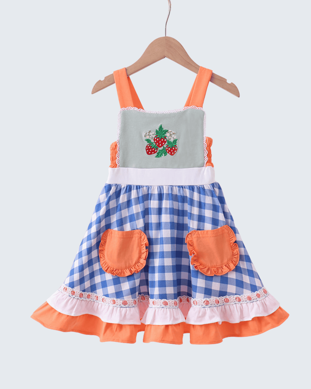 Children's dress with blue checkered skirt, orange straps, and pockets on a white background
