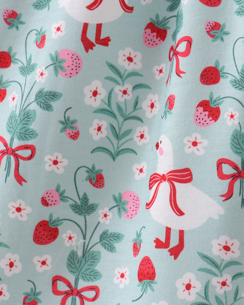 Fabric with a pattern of white birds, red bows, strawberries, and flowers on a light blue background.