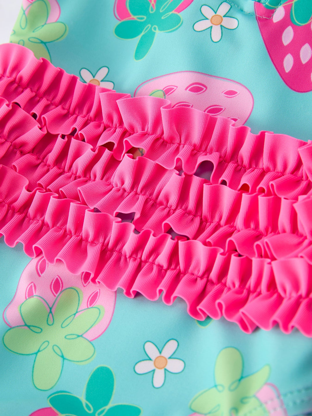 Close-up of pink ruffled fabric on a colorful floral background