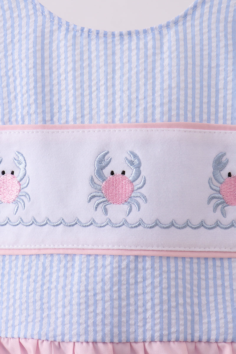 Light blue and pink swimsuit with crab embroidery on a white background