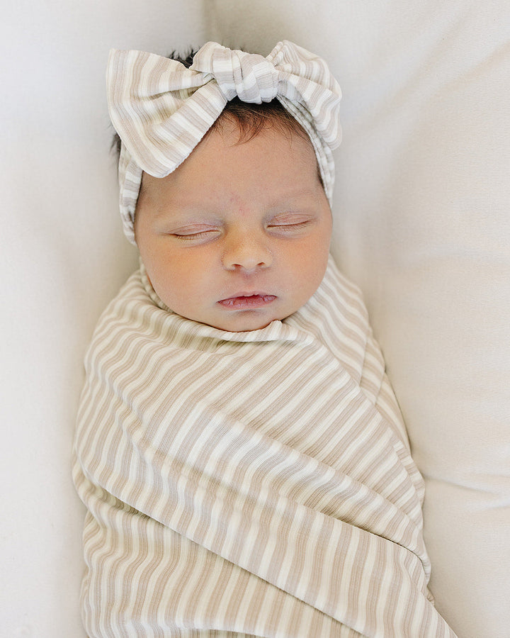Striped head wrap with knotted bow worn on baby’s forehead