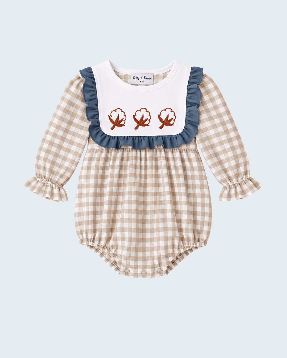 Gingham baby romper with navy ruffle bib and three embroidered leaf motifs
