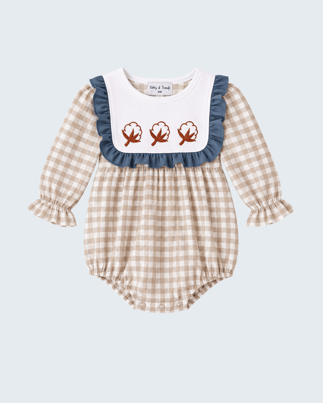 Gingham baby romper with navy ruffle bib and three embroidered leaf motifs