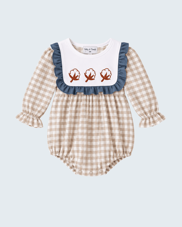 Gingham baby romper with navy ruffle bib and three embroidered leaf motifs