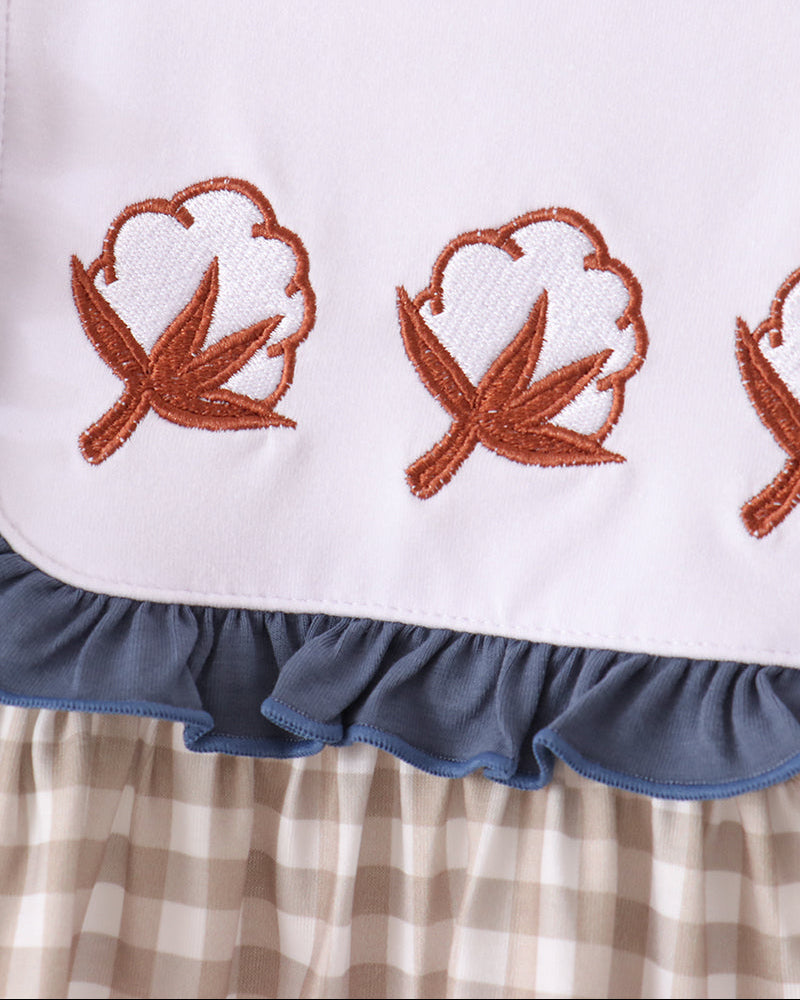 White gingham ruffle top with orange leaf embroidery and blue bib-style trim