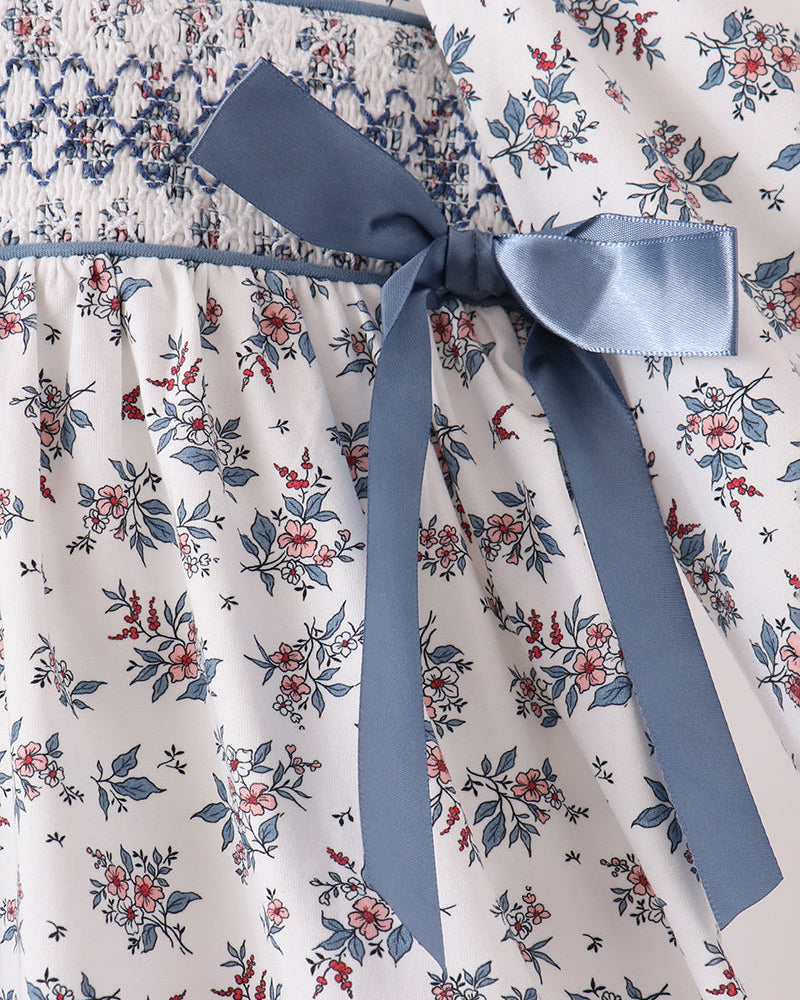 Blue ribbon bow on blue floral smocked-waist dress with gathered skirt