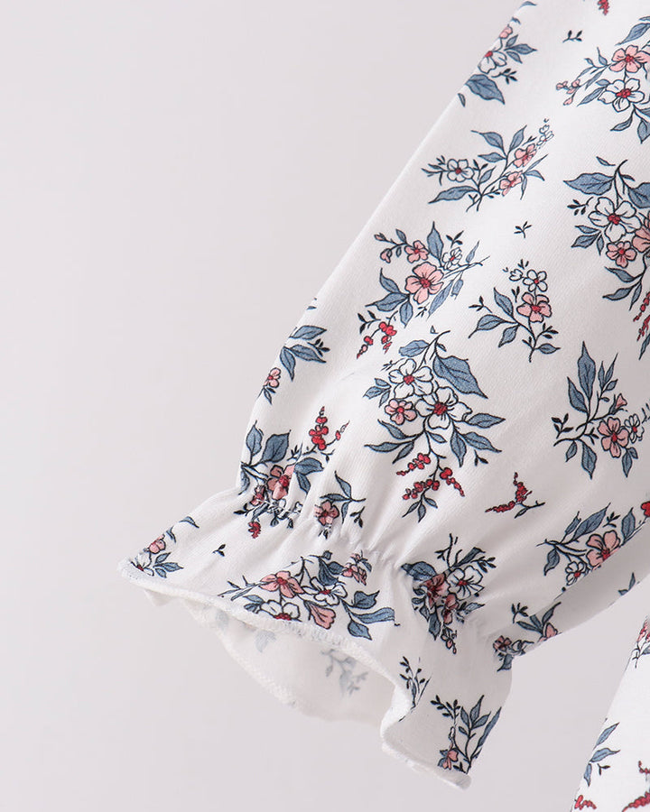 White floral top sleeve with gathered cuffs and small navy, pink, and red blossoms