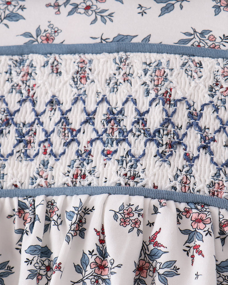 Smocked bodice blouse with gathered waist and blue floral print on white fabric