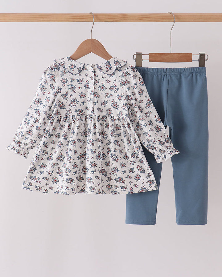 Floral long-sleeve dress top and solid blue pants set on matching hangers