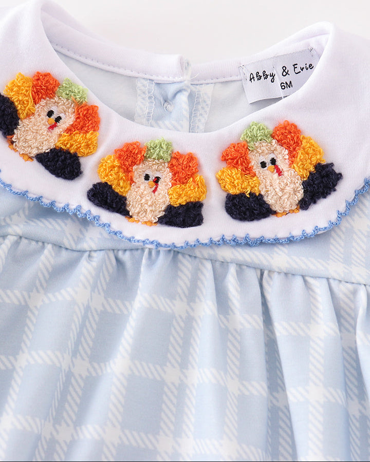 Girl bubble romper close-up: turkey applique with orange and black details, ruffled hem