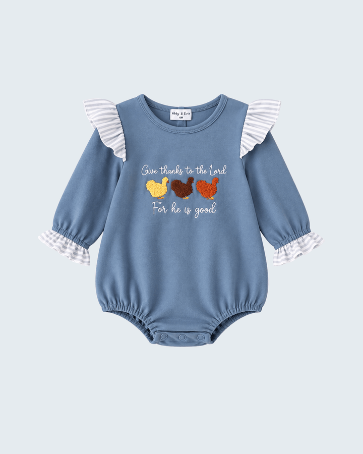 A baby long-sleeve romper in dusty blue, featuring white and gray striped ruffle details on the shoulders and cuffs, with a graphic of three colorful chickens and the text &
