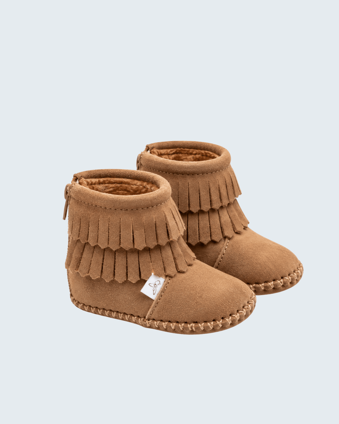 Light tan suede ankle boots with layered fringe trim and moccasin stitching, barefoot fit.