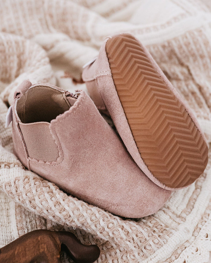 Dusty pink suede baby boots with elastic side gore and ridged sole tread