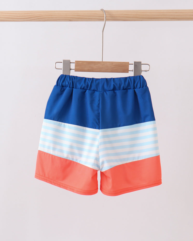 Color-blocked shorts with blue, white, and red stripes on a hanger against a light background