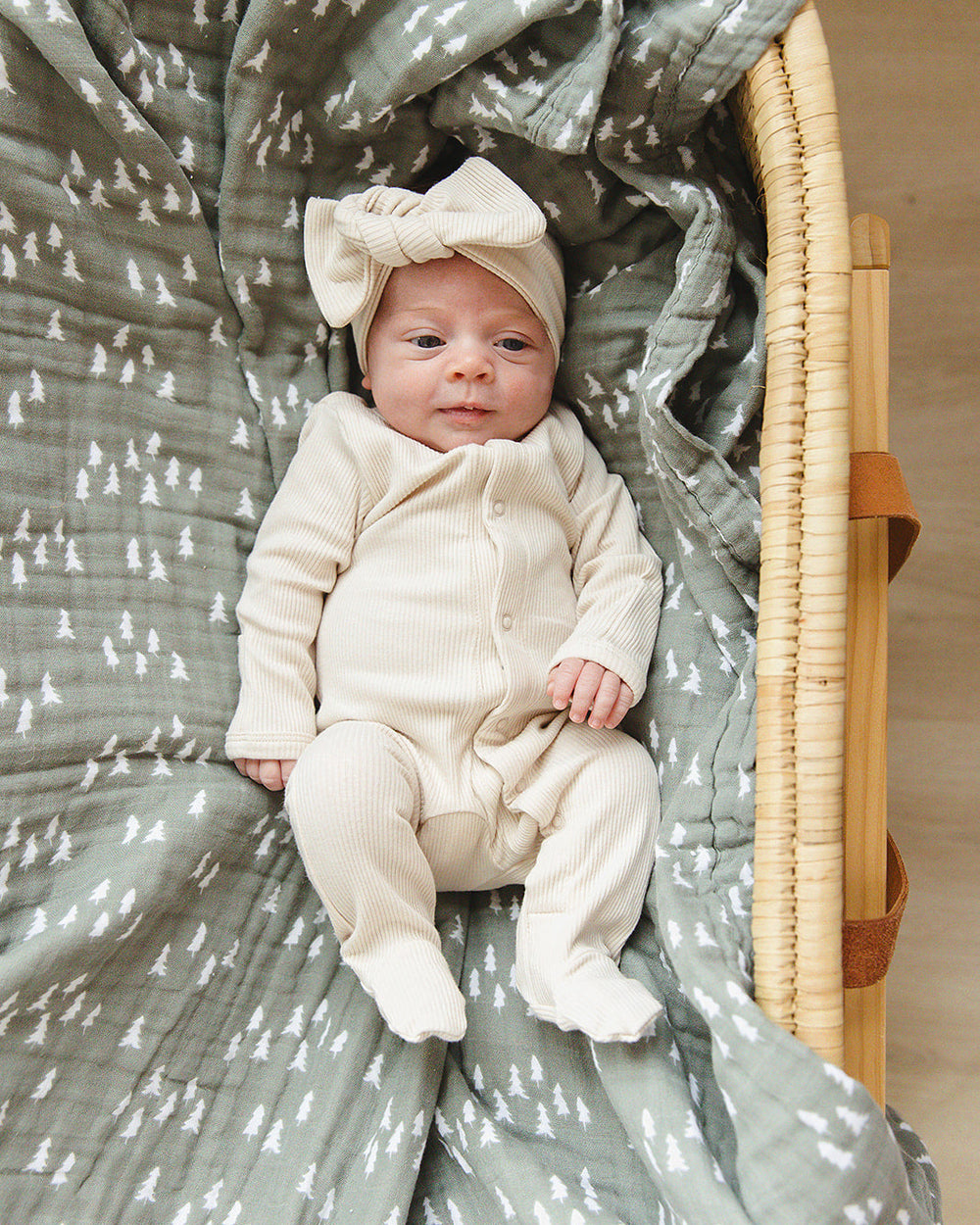 Cream ribbed snap-front baby footed onesie with long sleeves.